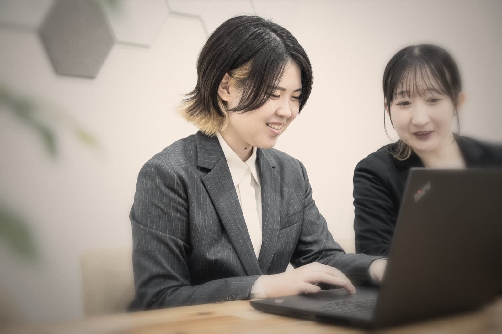 ノートパソコンを並べて話す、facingの調査員2人